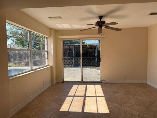 empty room with ceiling fan, baseboards, and tile patterned flooring
