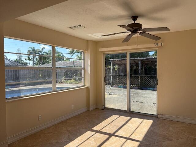 unfurnished sunroom featuring baseboards