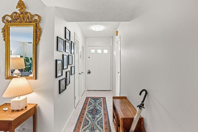 2520 Presidential Way Unit 203, West Palm Beach, FL 33401 - entryway featuring a textured ceiling, light tile patterned floors, and baseboards