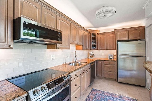 2520 Presidential Way Unit 203, West Palm Beach, FL 33401 - kitchen featuring appliances with stainless steel finishes, a sink, stone countertops, glass insert cabinets, and tasteful backsplash