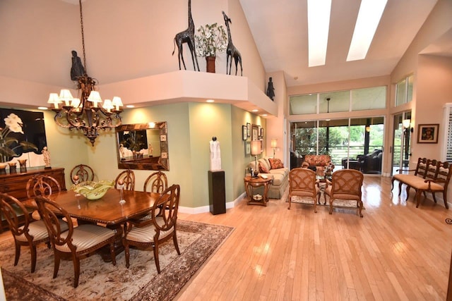 5845 NW 24th Ave Unit 1103, Boca Raton, FL 33496 - dining area featuring a chandelier, high vaulted ceiling, light wood-style floors, and baseboards
