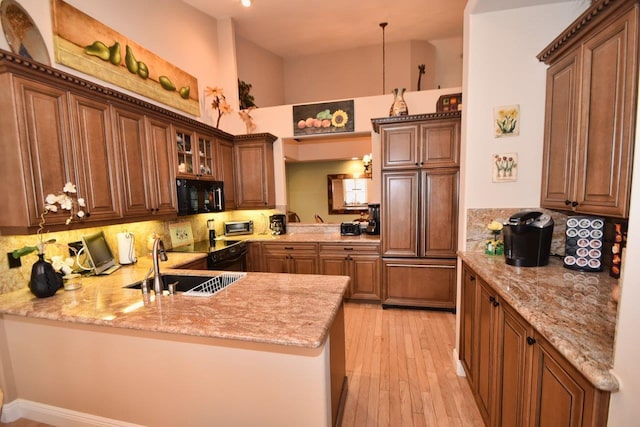 5845 NW 24th Ave Unit 1103, Boca Raton, FL 33496 - kitchen with black microwave, a peninsula, decorative backsplash, a sink, and glass insert cabinets