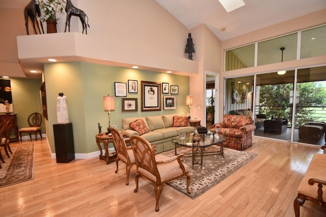 5845 NW 24th Ave Unit 1103, Boca Raton, FL 33496 - living room with a towering ceiling, light wood finished floors, baseboards, and a skylight