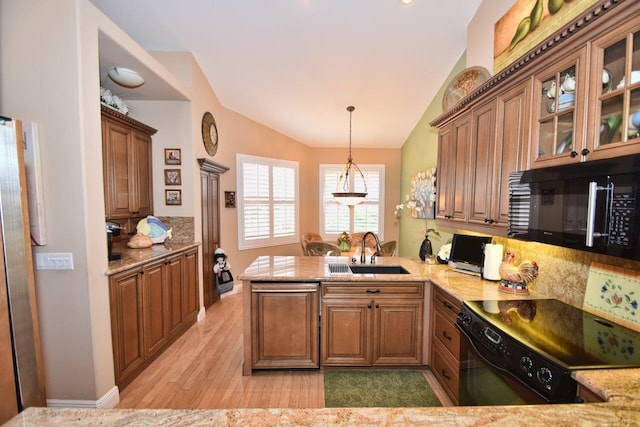 5845 NW 24th Ave Unit 1103, Boca Raton, FL 33496 - kitchen featuring black appliances, a sink, lofted ceiling, a peninsula, and light wood finished floors