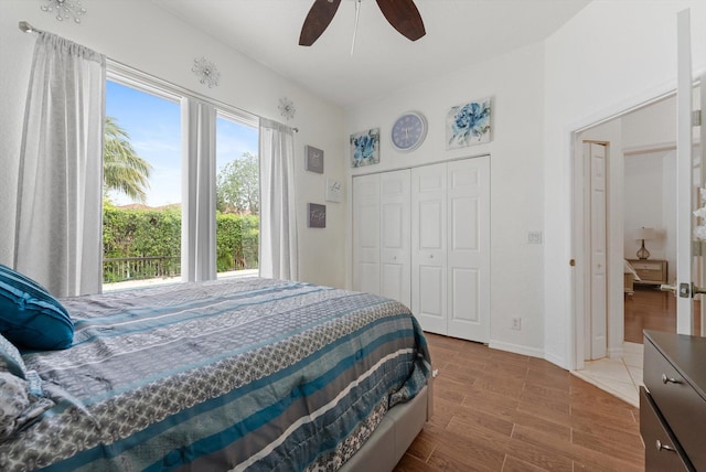 bedroom with wood finished floors, a closet, ceiling fan, and baseboards