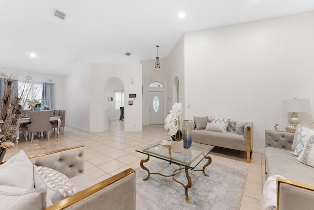 living area featuring arched walkways, light tile patterned flooring, baseboards, a high ceiling, and recessed lighting