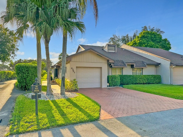 4721 Fountains Dr S, Lake Worth, FL 33467 - view of front facade with decorative driveway, an attached garage, stucco siding, a shingled roof, and a front yard