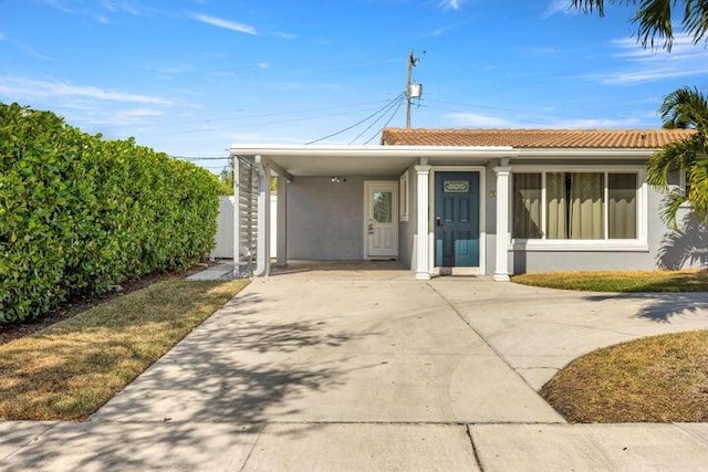 921 SE 13th Ct, Deerfield Beach, FL 33441 - view of front facade featuring driveway, stucco siding, an attached carport, and a tiled roof