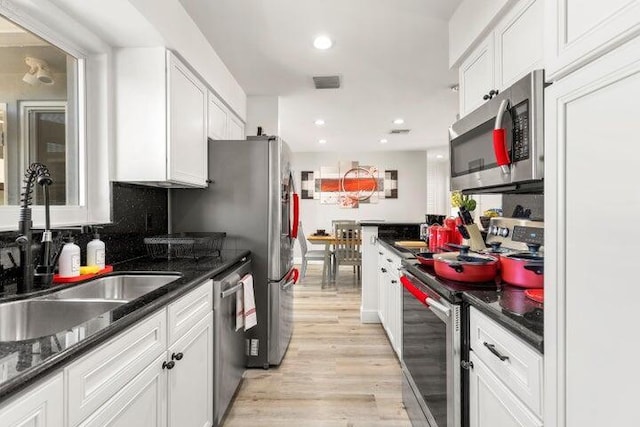 921 SE 13th Ct, Deerfield Beach, FL 33441 - kitchen featuring appliances with stainless steel finishes, a sink, light wood finished floors, white cabinetry, and recessed lighting