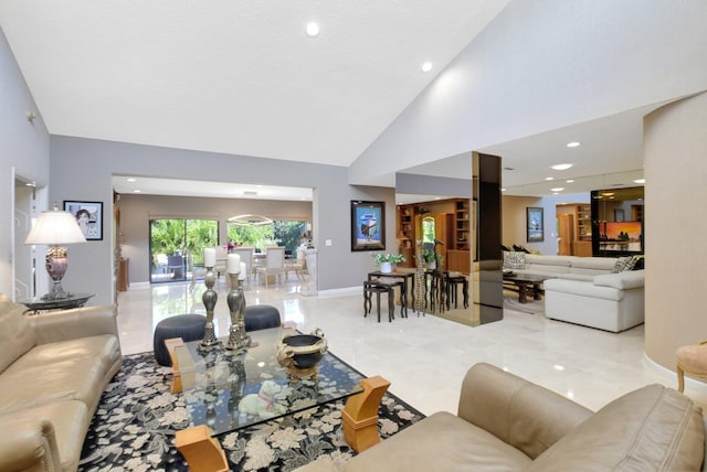 living room featuring high vaulted ceiling and baseboards