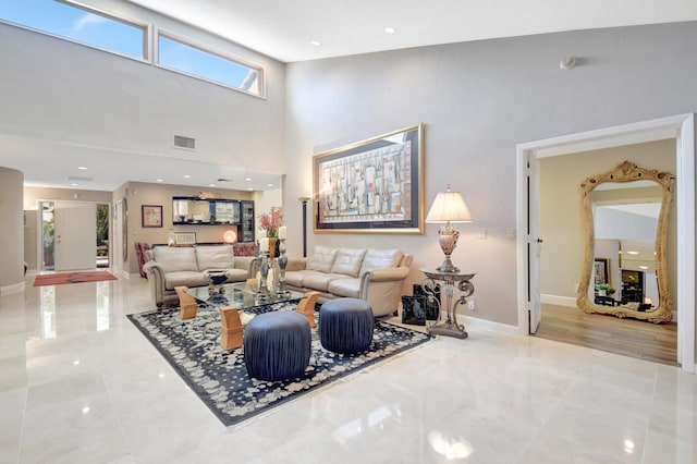 living area with a towering ceiling and baseboards