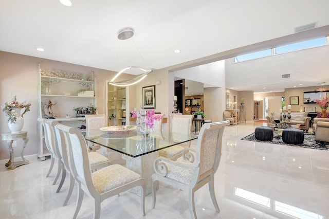 tiled dining space with recessed lighting and baseboards