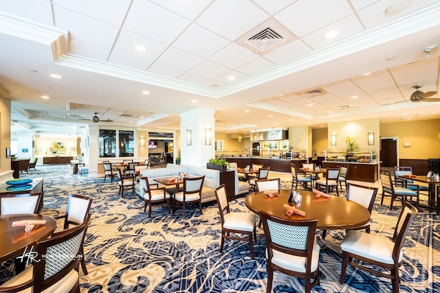 dining area featuring ornamental molding, a tray ceiling, decorative columns, and recessed lighting