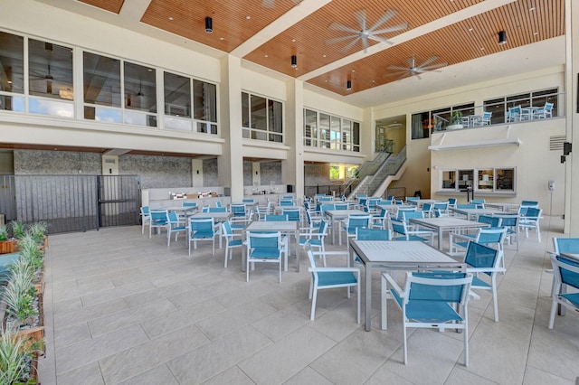 view of patio / terrace with stairs, a ceiling fan, and outdoor dining space