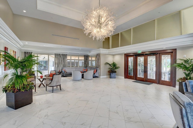 lobby with a towering ceiling, recessed lighting, and crown molding