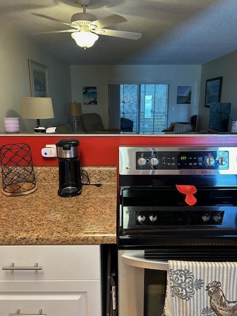 2724 S Garden Dr Unit 311, Lake Worth, FL 33461 - kitchen featuring stainless steel range with electric cooktop, ceiling fan, white cabinetry, a textured ceiling, and open floor plan