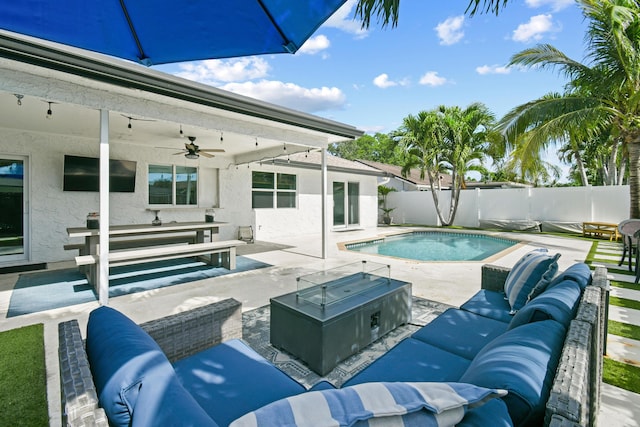 view of swimming pool with outdoor lounge area, a patio, a fenced backyard, and ceiling fan