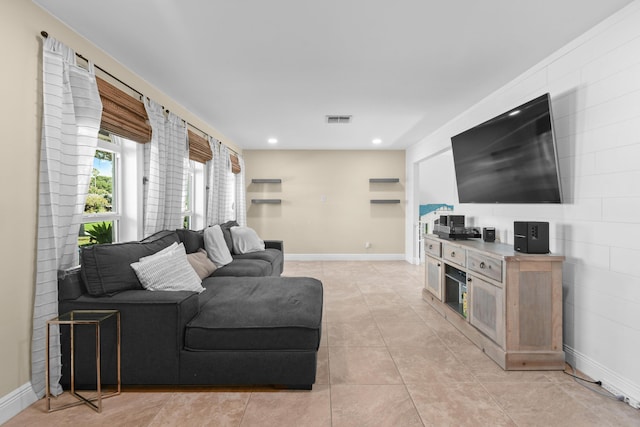living room featuring light tile patterned floors, baseboards, and recessed lighting