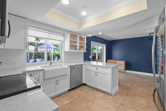 kitchen featuring dishwasher, a sink, crown molding, a peninsula, and backsplash