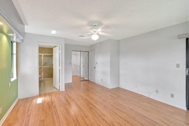 6078 Sunny Pointe Cir, Delray Beach, FL 33484 - unfurnished bedroom with light wood-type flooring, baseboards, connected bathroom, a textured ceiling, and a ceiling fan