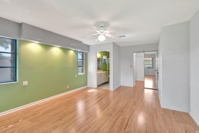 6078 Sunny Pointe Cir, Delray Beach, FL 33484 - empty room with ceiling fan, a barn door, light wood finished floors, and baseboards