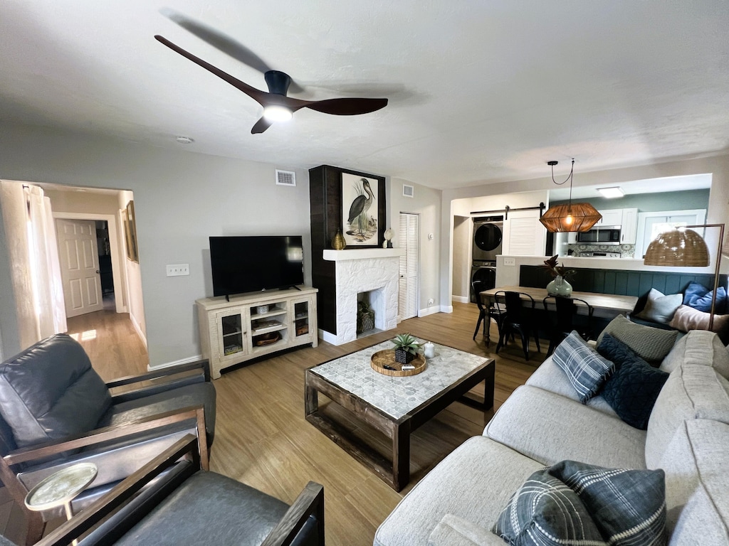 404 S M St Unit 1, Lake Worth Beach, FL 33460 - living area featuring stacked washer and clothes dryer, baseboards, a ceiling fan, and a stone fireplace