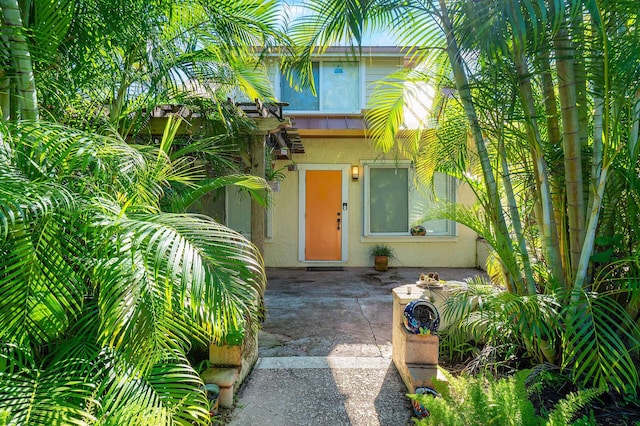 341 NE 7th Ave, Delray Beach, FL 33483 - doorway to property with stucco siding and a patio area