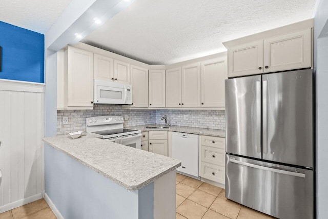 234 Pine Hov Cir Unit B-1, Greenacres, FL 33463 - kitchen featuring white appliances, a sink, a peninsula, light tile patterned flooring, and a textured ceiling