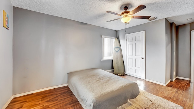 339 NW 5th Ave, Delray Beach, FL 33444 - bedroom featuring baseboards, a textured ceiling, wood finished floors, and a ceiling fan