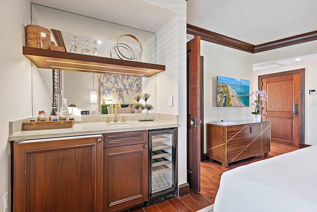301 Australian Ave Unit 305, Palm Beach, FL 33480 - indoor wet bar with beverage cooler, ornamental molding, and dark wood-style flooring