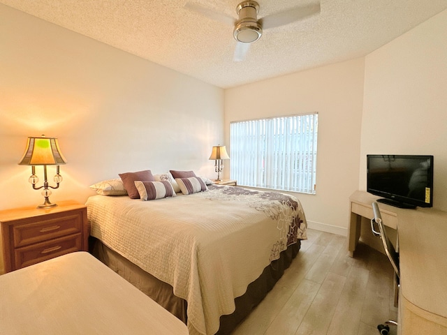 11666 Briarwood Cir Unit 1, Boynton Beach, FL 33437 - bedroom with light wood-style flooring, baseboards, a textured ceiling, and ceiling fan