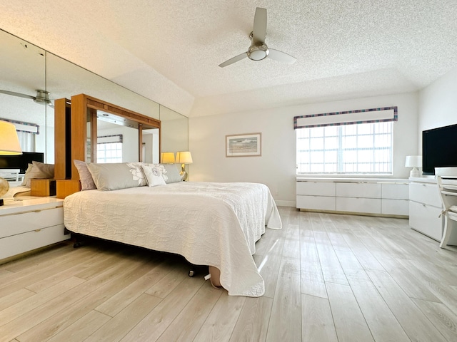11666 Briarwood Cir Unit 1, Boynton Beach, FL 33437 - bedroom with a textured ceiling, multiple windows, light wood finished floors, and a ceiling fan