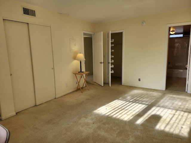 unfurnished bedroom with carpet flooring, ensuite bath, and baseboards