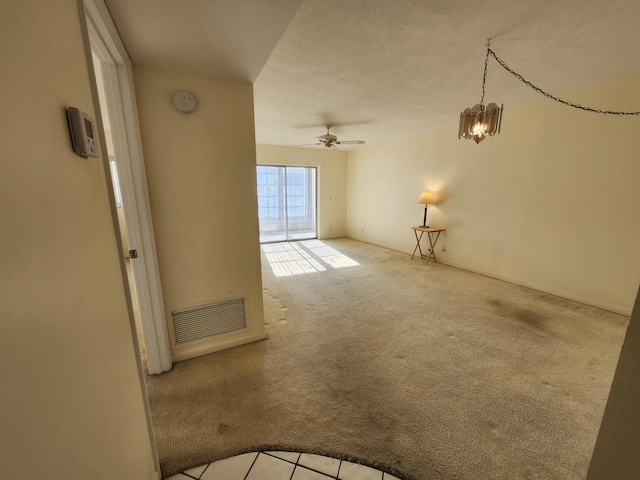 unfurnished room with carpet flooring, a chandelier, and ceiling fan