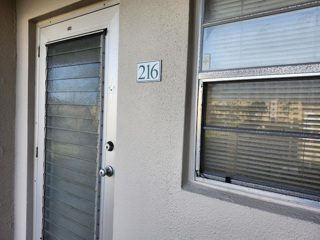 view of exterior entry featuring stucco siding