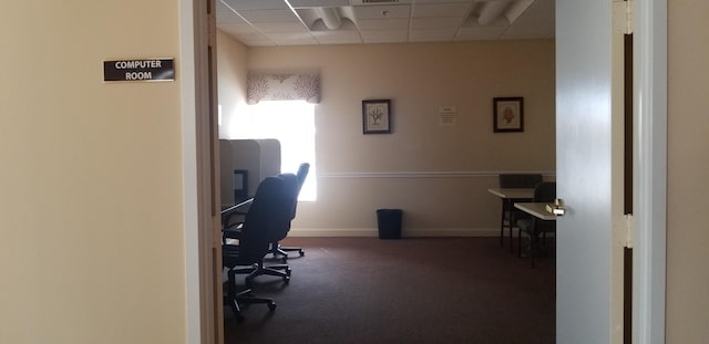 office area featuring a paneled ceiling, carpet floors, and baseboards