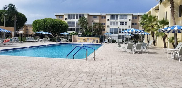 community pool featuring fence and a patio