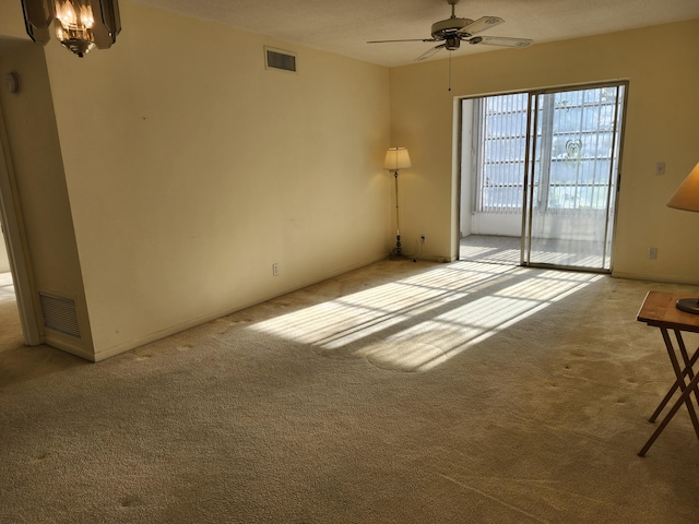 spare room with light colored carpet, ceiling fan, and baseboards