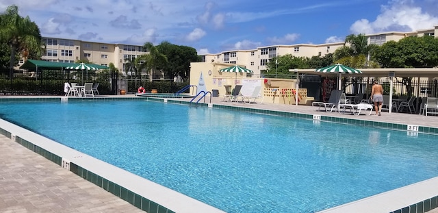community pool with fence and a patio area