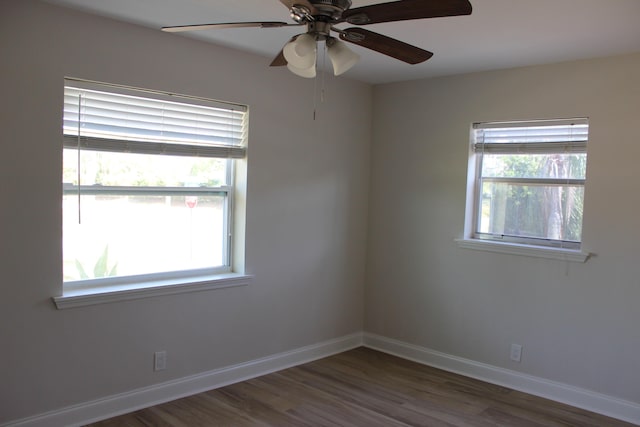 unfurnished room featuring ceiling fan, dark wood-style flooring, and baseboards