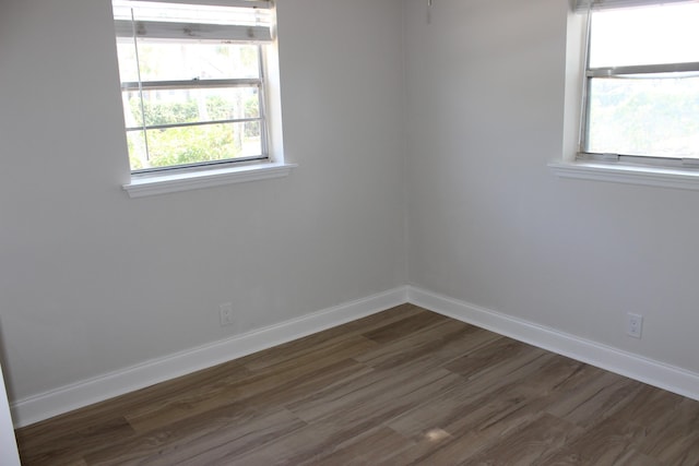 unfurnished room with dark wood-style floors and baseboards