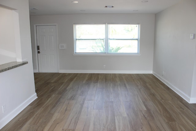 unfurnished living room with wood finished floors and baseboards