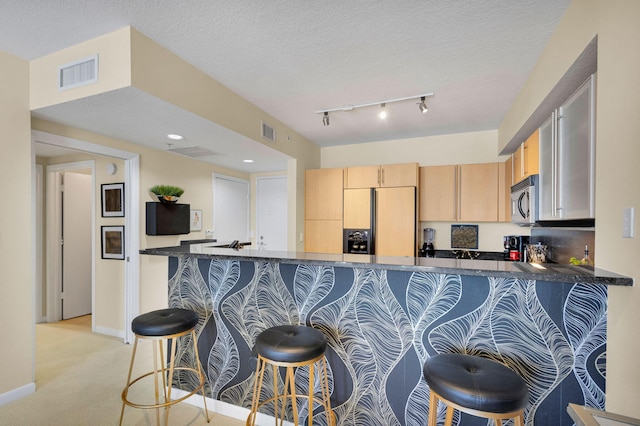 1551 N Flagler Dr Unit 804, West Palm Beach, FL 33401 - kitchen featuring paneled refrigerator, light brown cabinets, a kitchen bar, a peninsula, and baseboards