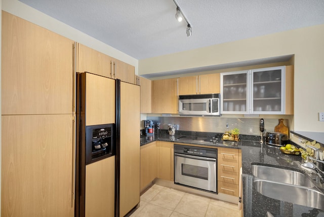 1551 N Flagler Dr Unit 804, West Palm Beach, FL 33401 - kitchen featuring appliances with stainless steel finishes, a sink, rail lighting, dark stone counters, and a textured ceiling