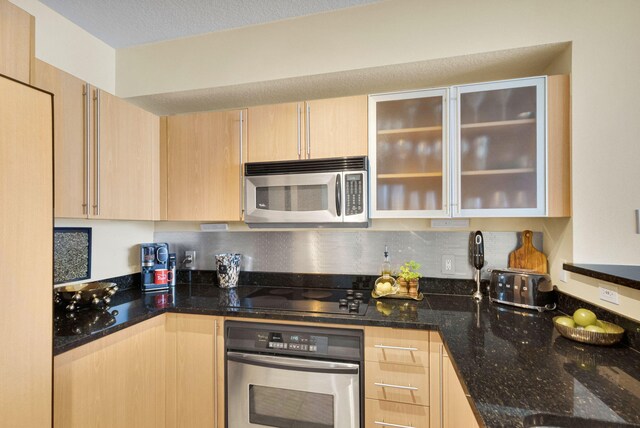 1551 N Flagler Dr Unit 804, West Palm Beach, FL 33401 - kitchen with appliances with stainless steel finishes, light brown cabinets, dark stone countertops, glass insert cabinets, and backsplash
