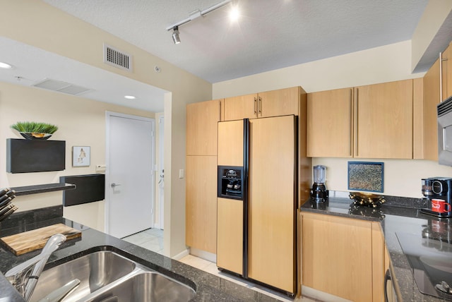 1551 N Flagler Dr Unit 804, West Palm Beach, FL 33401 - kitchen with fridge with ice dispenser, rail lighting, dark stone counters, light brown cabinets, and a textured ceiling