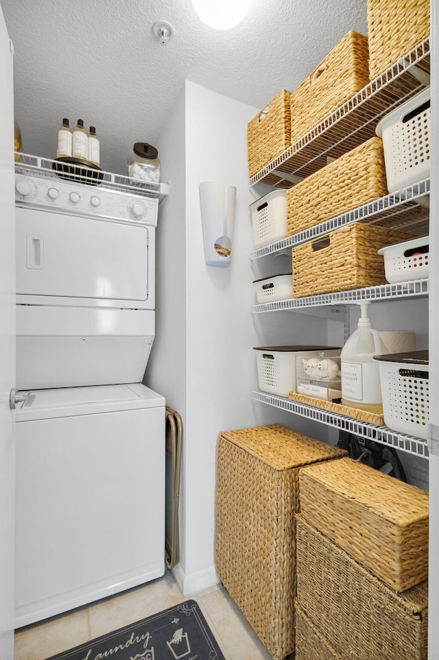 1551 N Flagler Dr Unit 804, West Palm Beach, FL 33401 - laundry area with estacked washer and dryer, tile patterned floors, baseboards, and a textured ceiling