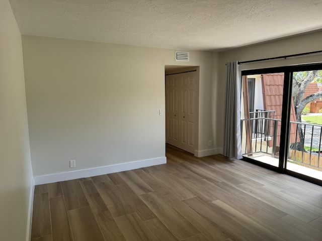 3400 Spanish Wells Dr Unit 52-C, Delray Beach, FL 33445 - spare room featuring wood finished floors, baseboards, and a textured ceiling