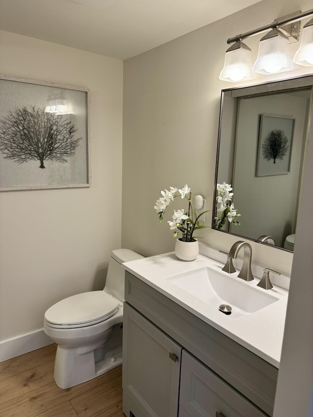 3400 Spanish Wells Dr Unit 52-C, Delray Beach, FL 33445 - half bath featuring toilet, vanity, wood finished floors, and baseboards