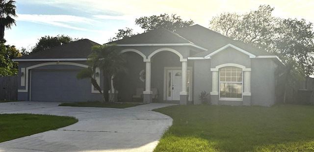 1895 Snapper Dr, Poinciana, FL 34759 - ranch-style home with stucco siding, driveway, a front yard, an attached garage, and covered porch